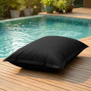 Pouf géant d'extérieur noir au bord d'une piscine