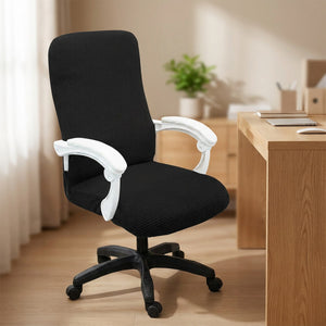 Housse de chaise de bureau noire en maille gaufrée installée sur un fauteuil dans un bureau lumineux