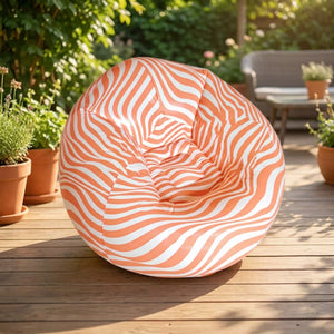 Fauteuil gonflable pouf géant rayé orange sur une terrasse en bois