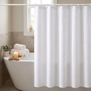 Rideau de douche jacquard tombant le long d'une baignoire avec bougie et serviettes