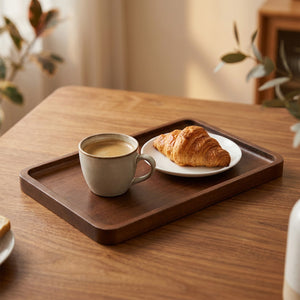 Plateau de service en bois foncé rectangulaire avec une tasse de café et un croissant sur une table en bois