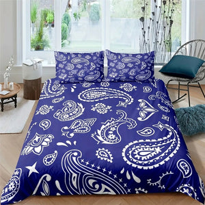 Parure de lit paisley bleu roi à grand motif sur un lit dans une chambre lumineuse