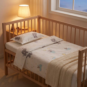 Parure de lit bébé motif éléphants sur un berceau avec lampe de chevet chaleureuse