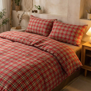 Parure de lit à carreaux rouges dans une chambre cocooning avec lampe de chevet