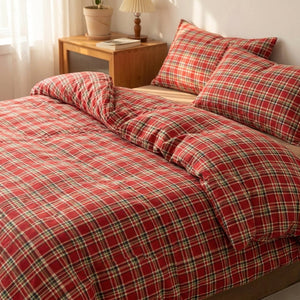 Parure de lit à carreaux rouges installée sur un lit fait dans une chambre chaleureuse