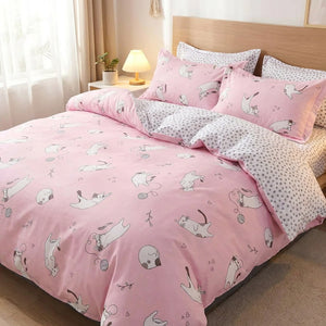 Parure de lit rose à chats joueurs et pelotes de laine sur un lit