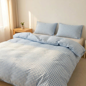 Parure de lit à carreaux vichy bleus sur un lit fait dans une chambre lumineuse