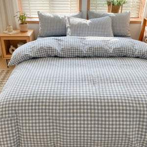 Parure de lit à carreaux vichy bleu installée sur un lit dans une chambre douce et lumineuse