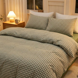 Parure de lit à carreaux vichy vert sur un lit dans une chambre chaleureuse avec lampe de chevet allumée