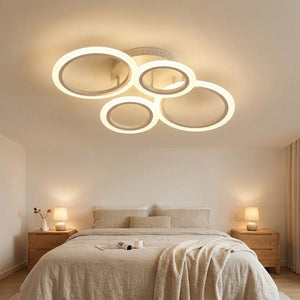 Plafonnier LED 4 anneaux allumé dans une chambre contemporaine