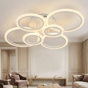 Plafonnier LED multi-anneaux blanc allumé dans un salon contemporain
