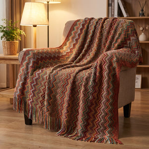 Plaid bohème à chevrons colorés rouge et rouille drapé sur un fauteuil