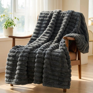 Plaid flanelle épaisse à larges rayures coloris gris foncé sur fauteuil en bois
