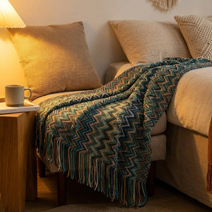 Plaid boho turquoise drapé près d'un lit avec lampe de chevet chaleureuse