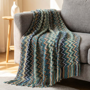 Plaid boho tricoté à chevrons turquoise avec franges drapé sur un canapé