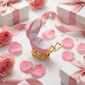 Coffret landau rose présenté en cadeau parmi des roses pétales et rubans satinés