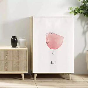 Rideau velcro à motif d'oiseau rose sur un meuble en bois dans une pièce claire