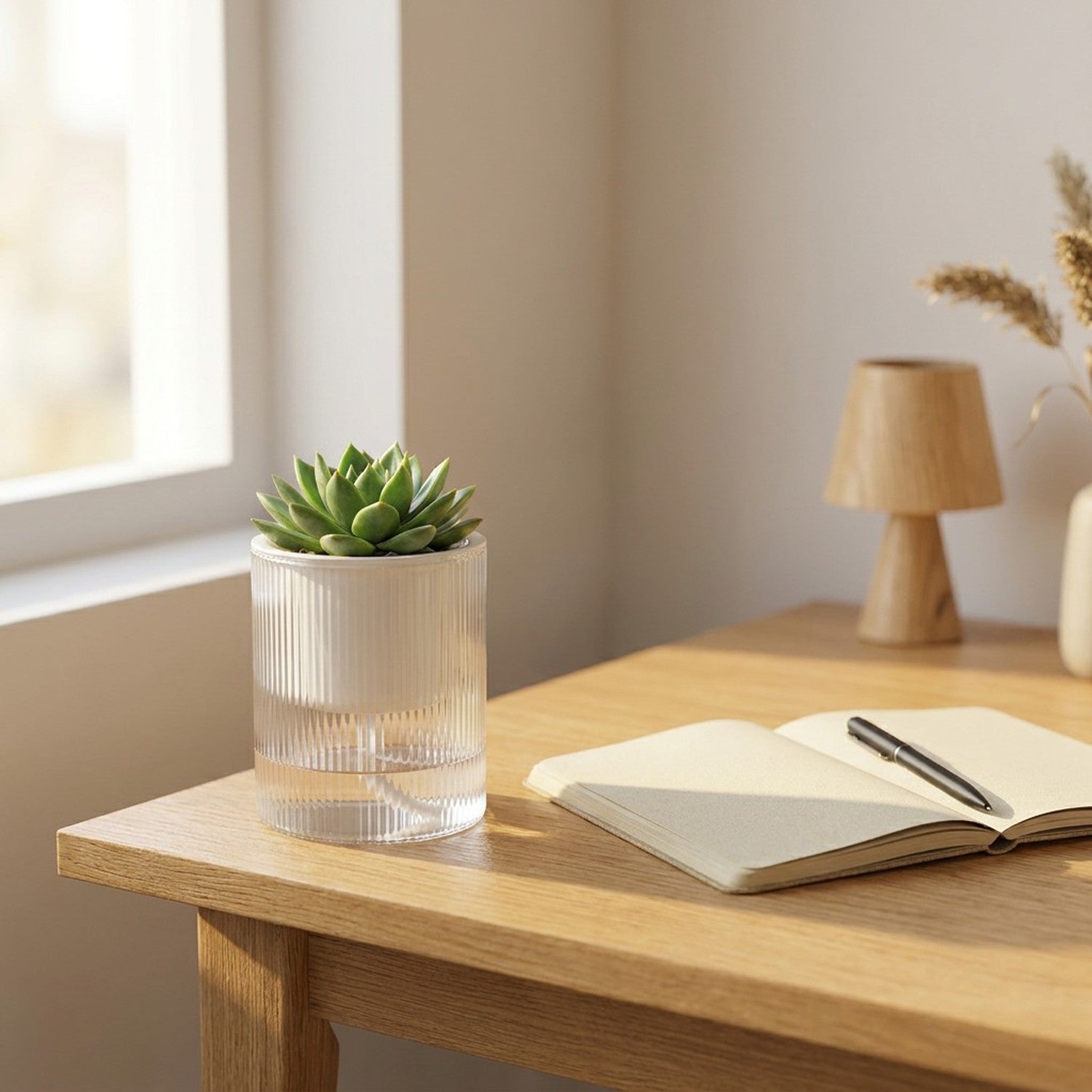 Pot auto-arrosant transparent avec succulente sur bureau en bois à côté d'un carnet ouvert, lumière matinale douce