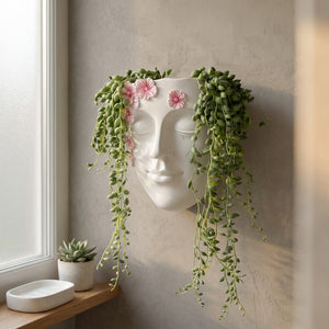 Pot mural visage en résine dans une salle de bain scandinave avec plantes retombantes