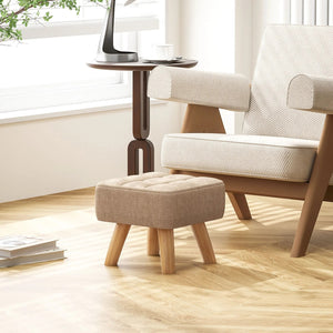 Pouf repose pied près d'un fauteuil beige dans un salon lumineux