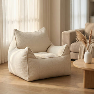 Housse de pouf bouclé beige forme fauteuil dans un salon scandinave près d'un canapé