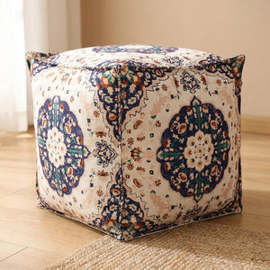Pouf marocain housse ivoire à motif floral bleu marine vu de trois quarts