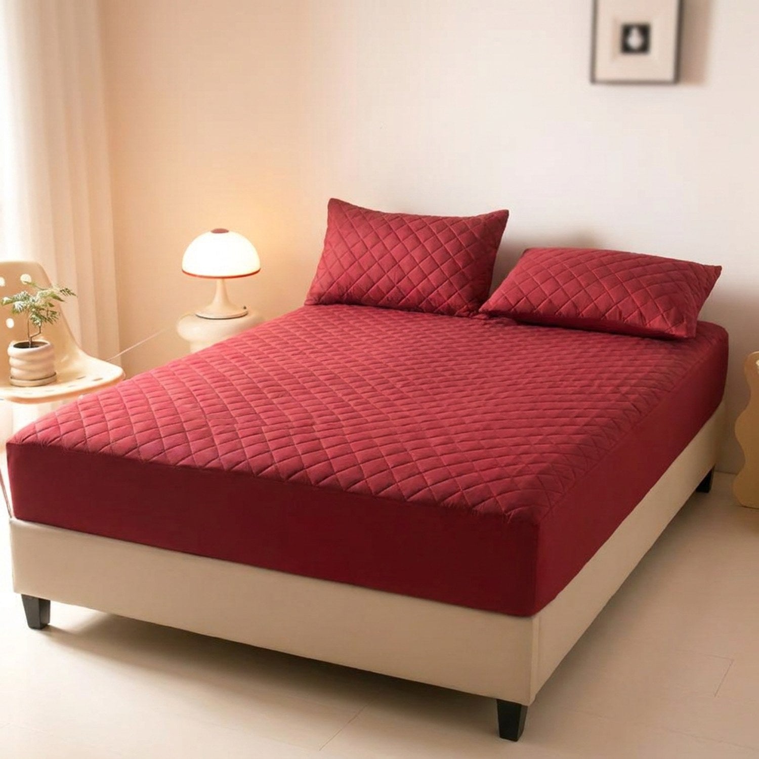 Protège matelas bordeaux installé sur un lit double dans une chambre chaleureuse