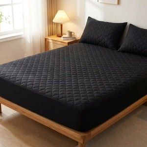 Protège matelas imperméable matelassé noir installé sur un lit