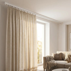 Rail de rideau blanc au plafond d'un salon avec un rideau beige