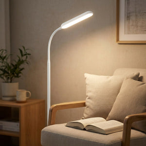Lampadaire LED orienté au-dessus d'un fauteuil pour éclairer un livre ouvert en lecture