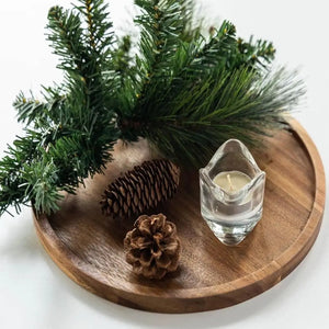 Plateau rond en bois d'acacia avec bougie et branches de pin