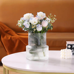 Vase tulipe en verre à côtes avec bouquet de roses sur table ronde en marbre crème