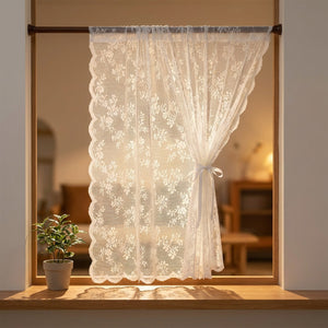 Rideau voilage blanc en dentelle florale suspendu à une fenêtre lumineuse avec tringle