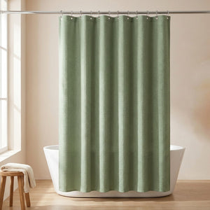 Rideau de douche coloris vert sauge suspendu dans une salle de bain