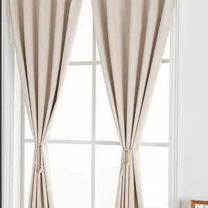 Deux pans de rideau occultant beige noués devant une fenêtre