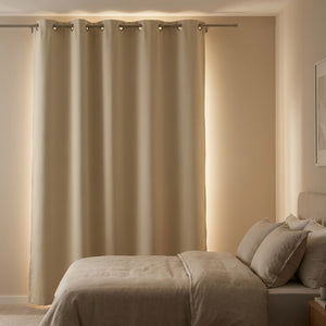 Rideau occultant beige bloquant la lumière du matin dans une chambre cocooning