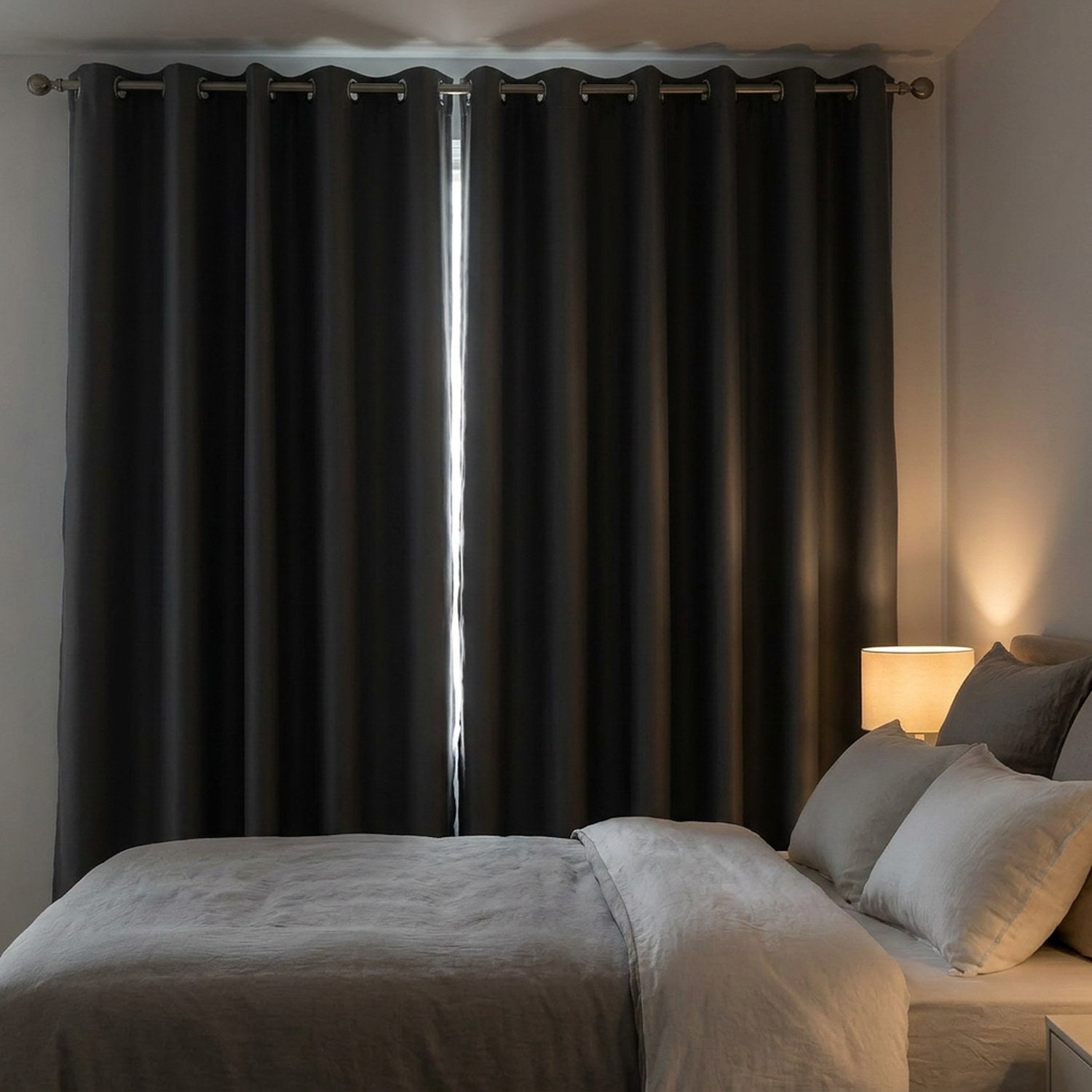 Rideau occultant gris foncé tiré devant une fenêtre de chambre pour faire le noir