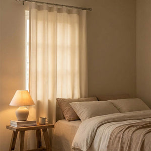 Rideaux en velours chenille crème dans une chambre chaleureuse près d'un lit
