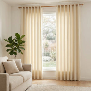 Rideaux en velours chenille crème encadrant une fenêtre dans un salon scandinave