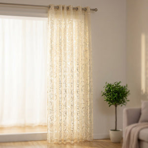 Rideau voilage crème au motif baroque ajouré suspendu à une fenêtre lumineuse de salon