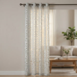 Rideau voilage gris perle au motif baroque ajouré suspendu à une fenêtre
