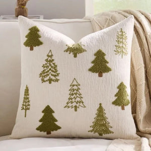 Housse de coussin brodée de sapins verts sur canapé blanc