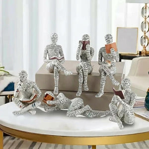 Ensemble de figurines de lecteurs en résine avec motifs typographiques sur table basse