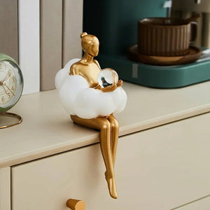 Les deux figurines dorées pensive et lectrice sur étagère avec livres de décoration