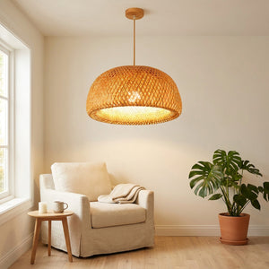 Suspension bambou naturel dans un coin lecture avec fauteuil crème et plante monstera