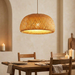 Suspension bambou allumée au-dessus d'une table à manger en bois ambiance chaleureuse