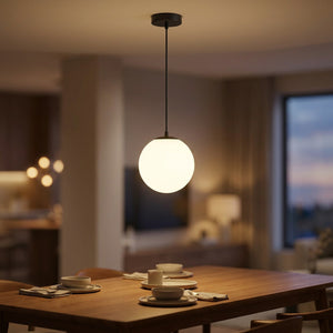 Suspension boule de verre opale avec monture noire suspendue au-dessus d'une table de salle à manger