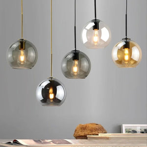 Suspension globe en verre transparent avec ampoule filament allumée vue de face