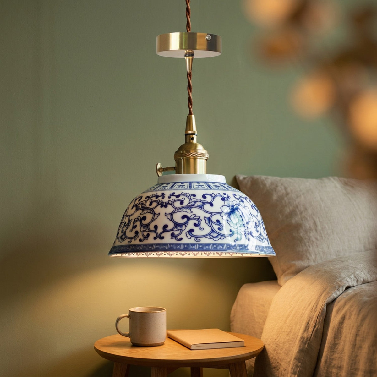 Suspension céramique allumée au-dessus d'une table de chevet dans une chambre sauge