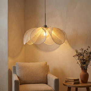 Suspension pétales de tissu illuminant un coin lecture fauteuil beige et bouquet séché